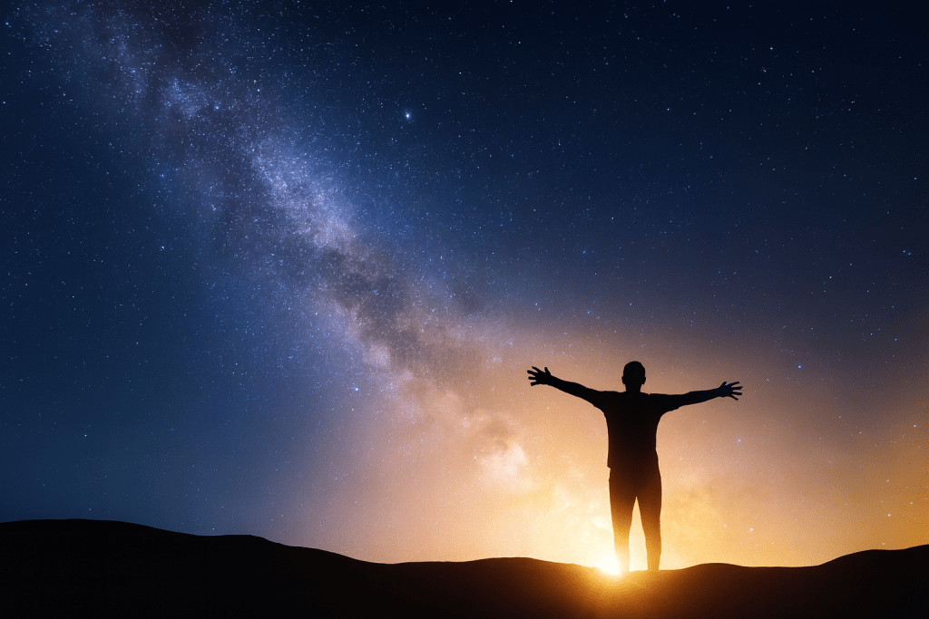 Silhouette of a person standing with arms outstretched against a starry night sky, symbolizing wonder and gratitude.